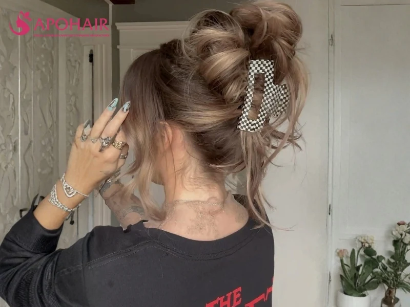 Loose brown updo held at the back with a pearl-decorated claw clip