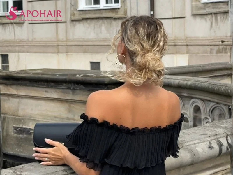 Loose blonde low bun viewed from behind with softly twisted sections